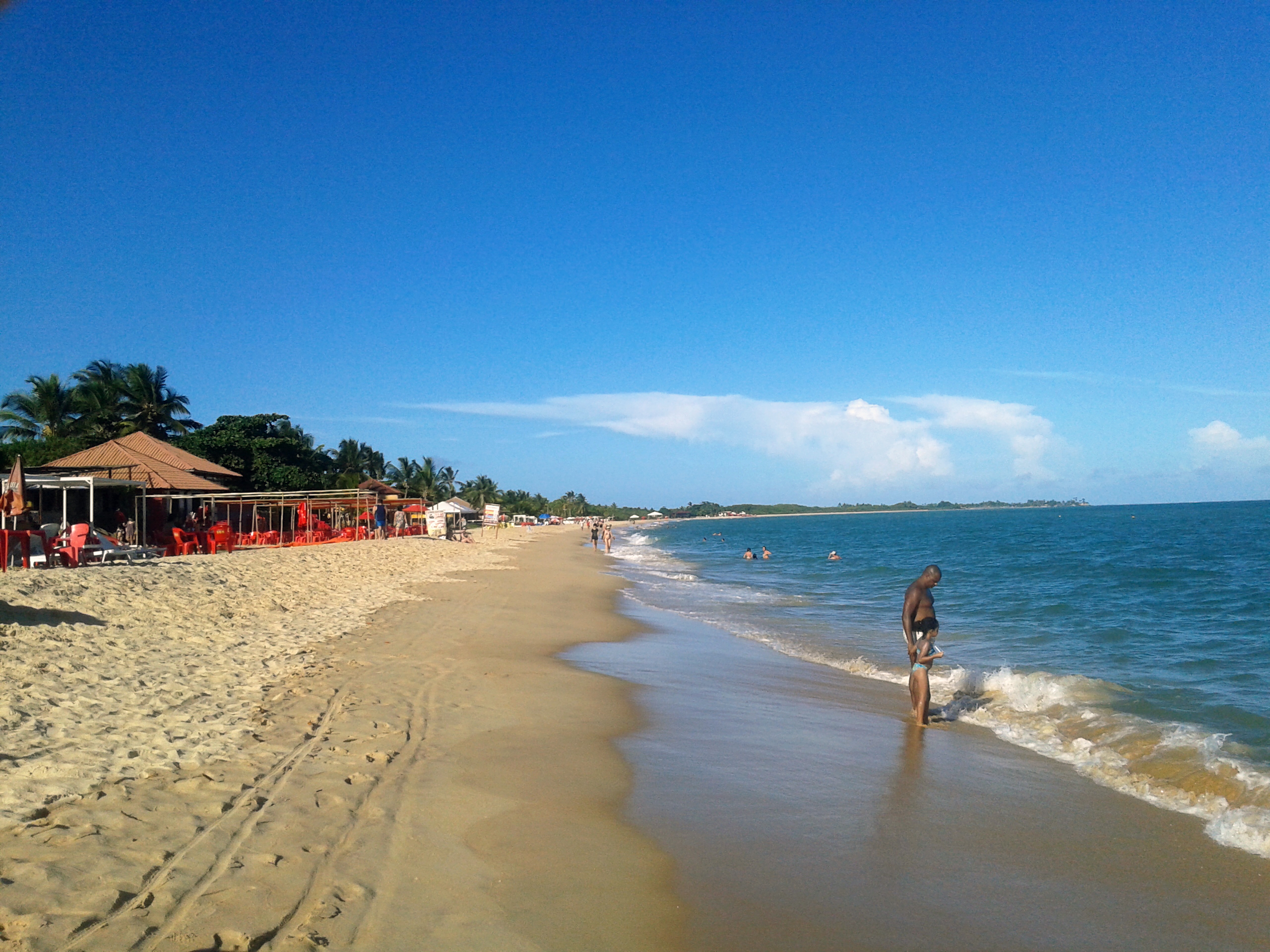 Faixa de areia, mar e barracas na Praia de Taperapuã, Porto Seguro